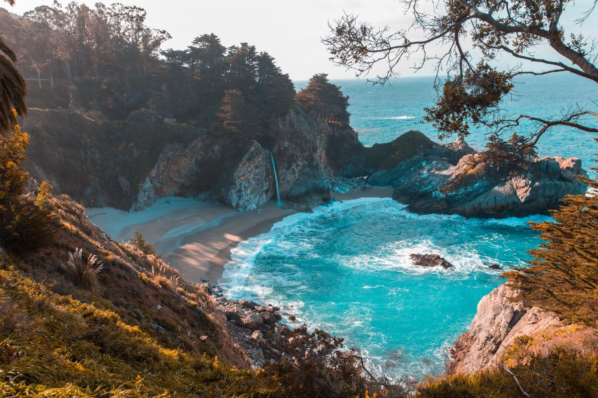 Turquoise beach cove surrounded by rocky terrain.